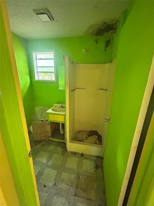 1904 Lillian St, Pasadena, TX 77502 - bathroom featuring tile patterned floors, a stall shower, a textured ceiling, and vanity