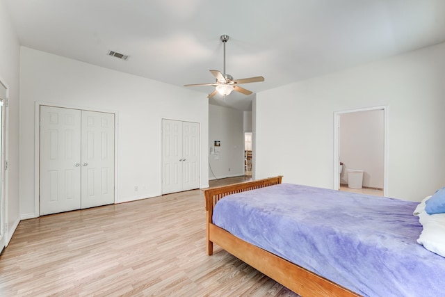131 Canary Ln, Coldspring, TX 77331 - bedroom featuring two closets, light wood-style floors, ensuite bathroom, and a ceiling fan