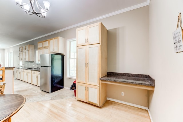 131 Canary Ln, Coldspring, TX 77331 - kitchen featuring freestanding refrigerator, dark countertops, ornamental molding, tasteful backsplash, and a chandelier