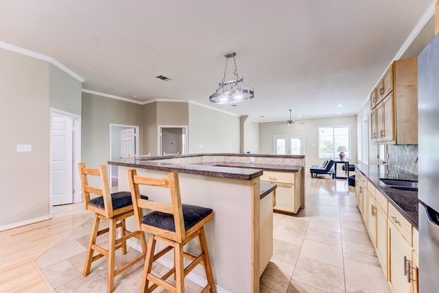 131 Canary Ln, Coldspring, TX 77331 - kitchen with a breakfast bar, a ceiling fan, a large island, crown molding, and hanging light fixtures
