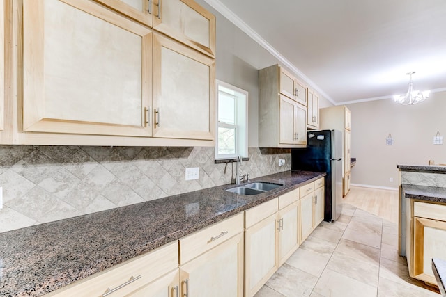 131 Canary Ln, Coldspring, TX 77331 - kitchen with freestanding refrigerator, ornamental molding, backsplash, dark stone countertops, and a chandelier