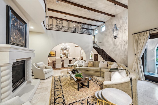 3751 Aberdeen Way, Houston, TX 77025 - living room with arched walkways, a chandelier, beam ceiling, a towering ceiling, and a glass covered fireplace