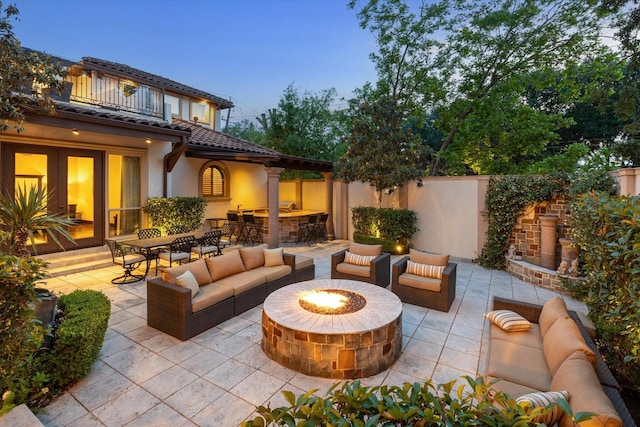 3751 Aberdeen Way, Houston, TX 77025 - patio terrace at dusk featuring an outdoor living space with a fire pit, a balcony, a patio area, and a bar
