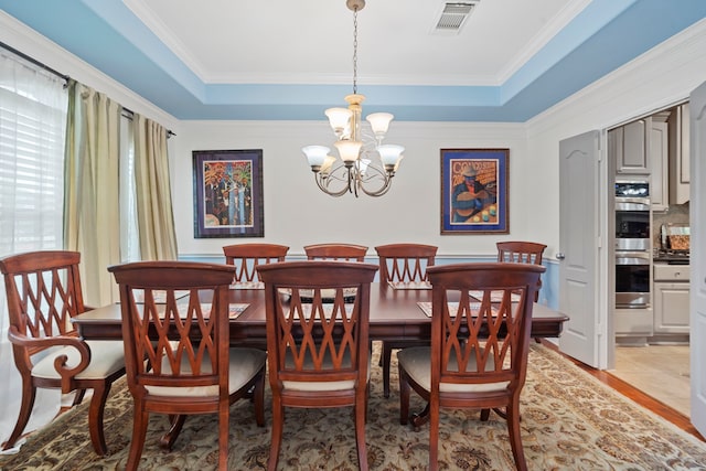 2326 Vinemead Ct, Katy, TX 77450 - dining area with a chandelier, light wood-style floors, crown molding, and a tray ceiling