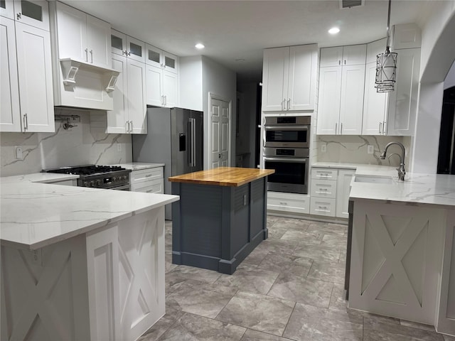 14410 Brentshire Ln, Houston, TX 77069 - kitchen with wooden counters, stainless steel appliances, a peninsula, backsplash, and exhaust hood