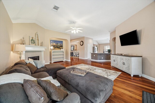 7206 Broadelm Dr, Houston, TX 77095 - living room with arched walkways, wood finished floors, a ceiling fan, and a fireplace
