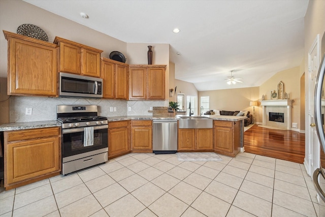 7206 Broadelm Dr, Houston, TX 77095 - kitchen with stainless steel appliances, open floor plan, a peninsula, decorative backsplash, and a ceiling fan