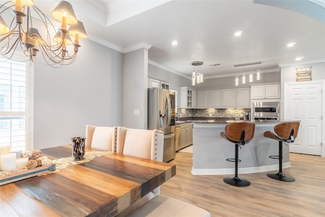 503 Detering St, Houston, TX 77007 - dining space with a chandelier, light wood-style flooring, crown molding, and recessed lighting