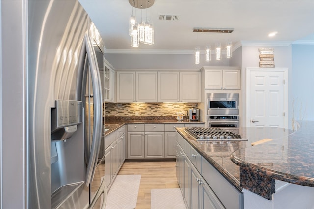 503 Detering St, Houston, TX 77007 - kitchen featuring stainless steel appliances, ornamental molding, light wood finished floors, decorative backsplash, and pendant lighting