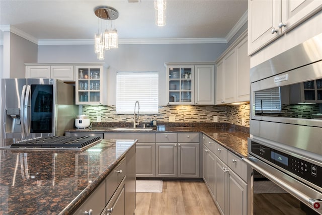 503 Detering St, Houston, TX 77007 - kitchen featuring appliances with stainless steel finishes, backsplash, light wood-style floors, a chandelier, and crown molding