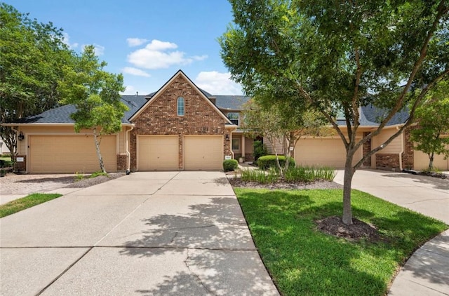 8814 Silent Willow Ln, Sugar Land, TX 77479 - view of front of home with brick siding, driveway, a garage, and a front lawn