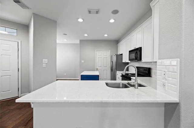 8814 Silent Willow Ln, Sugar Land, TX 77479 - kitchen featuring black appliances, a kitchen island, decorative backsplash, dark wood-type flooring, and white cabinets