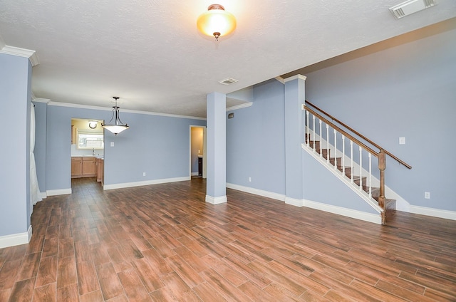 15018 Moss Boulder Ct, Houston, TX 77084 - unfurnished living room with wood finished floors, stairway, a textured ceiling, and crown molding