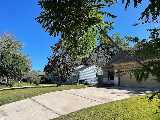 4106 Friar Point Rd, Houston, TX 77047 - view of front of house with a front yard, an attached garage, concrete driveway, and brick siding