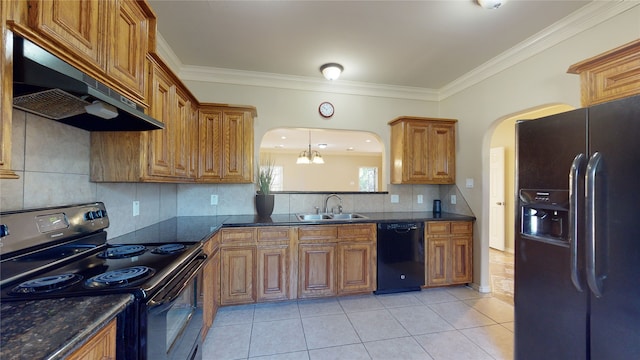 4106 Friar Point Rd, Houston, TX 77047 - kitchen with black appliances, under cabinet range hood, arched walkways, brown cabinets, and ornamental molding