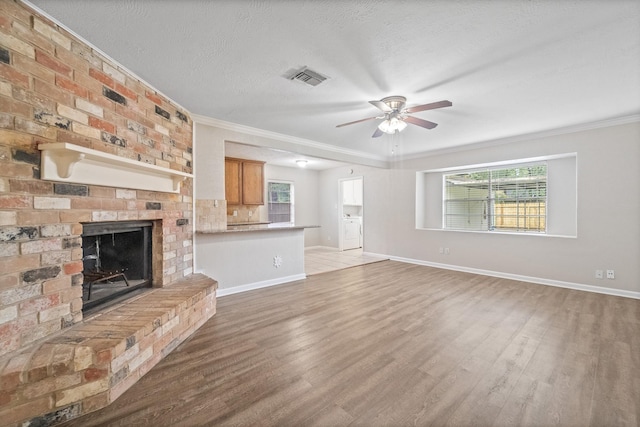 407 Gamewood Dr, Spring, TX 77386 - unfurnished living room with a ceiling fan, wood finished floors, ornamental molding, a fireplace, and a textured ceiling