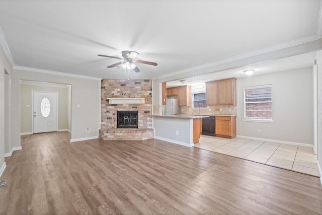 407 Gamewood Dr, Spring, TX 77386 - unfurnished living room with a ceiling fan, light wood-type flooring, ornamental molding, and a fireplace