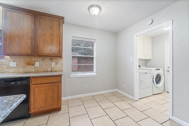 407 Gamewood Dr, Spring, TX 77386 - kitchen with washing machine and dryer, black dishwasher, a textured ceiling, light tile patterned floors, and decorative backsplash