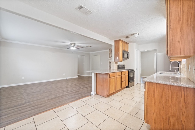 407 Gamewood Dr, Spring, TX 77386 - kitchen featuring black appliances, light stone countertops, ceiling fan, open floor plan, and ornamental molding