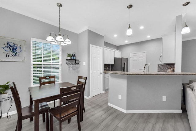 3534 Cork Dr, Houston, TX 77047 - dining area featuring light wood finished floors, a chandelier, and recessed lighting