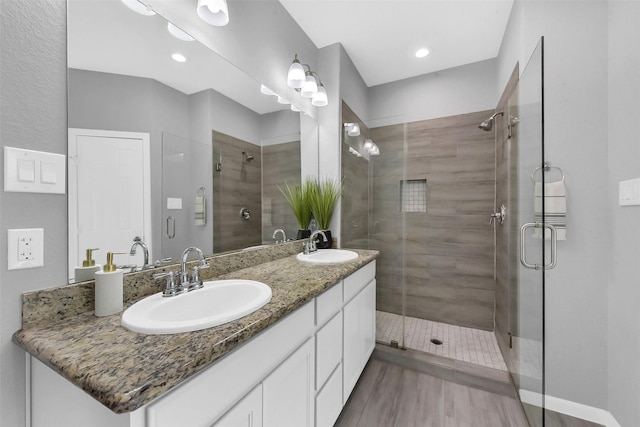 3534 Cork Dr, Houston, TX 77047 - bathroom featuring a shower stall, double vanity, and wood finished floors