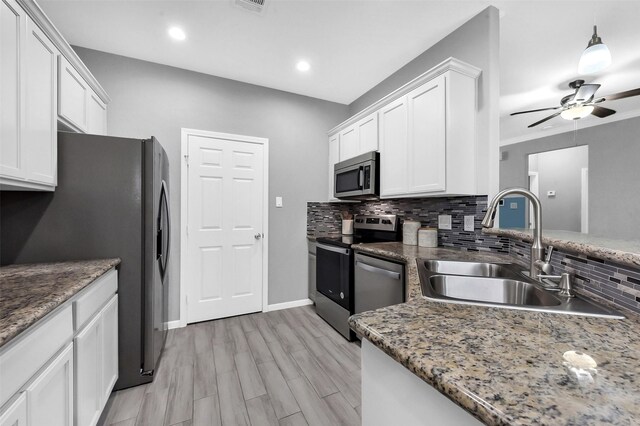 3534 Cork Dr, Houston, TX 77047 - kitchen with appliances with stainless steel finishes, white cabinets, decorative backsplash, a ceiling fan, and recessed lighting
