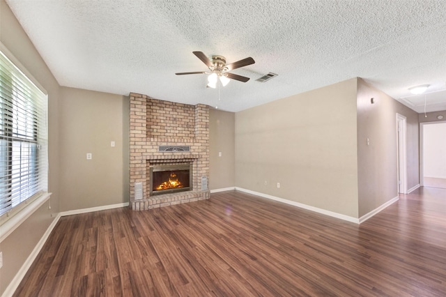 1002 Williams St, Cleveland, TX 77327 - unfurnished living room with ceiling fan, wood finished floors, attic access, a textured ceiling, and a brick fireplace
