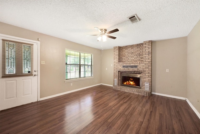 1002 Williams St, Cleveland, TX 77327 - unfurnished living room featuring ceiling fan, wood finished floors, a textured ceiling, and a brick fireplace