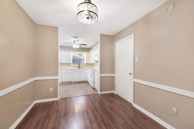 1002 Williams St, Cleveland, TX 77327 - unfurnished dining area with wood finished floors, a textured ceiling, a chandelier, and a ceiling fan