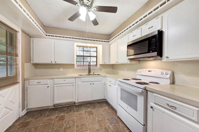 1002 Williams St, Cleveland, TX 77327 - kitchen with electric range, stainless steel microwave, white cabinetry, a textured ceiling, and light countertops