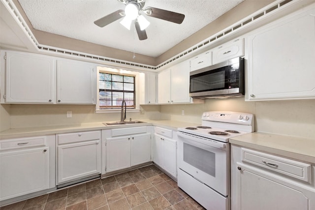 1002 Williams St, Cleveland, TX 77327 - kitchen featuring electric range, stainless steel microwave, white cabinetry, light countertops, and a textured ceiling