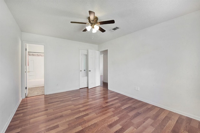 1002 Williams St, Cleveland, TX 77327 - unfurnished bedroom featuring wood finished floors, a textured ceiling, connected bathroom, and ceiling fan