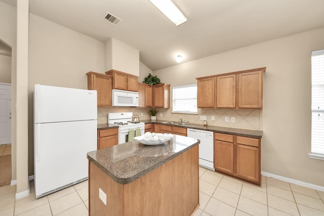 20234 Goss Hollow Ln, Katy, TX 77449 - kitchen with white appliances, lofted ceiling, decorative backsplash, a kitchen island, and light tile patterned floors