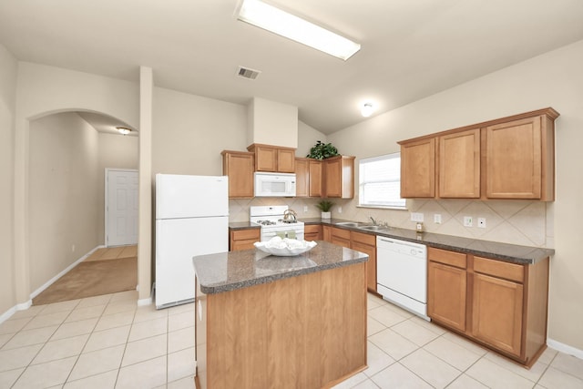20234 Goss Hollow Ln, Katy, TX 77449 - kitchen with white appliances, arched walkways, lofted ceiling, a center island, and decorative backsplash
