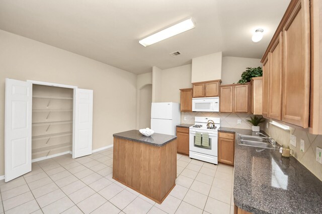 20234 Goss Hollow Ln, Katy, TX 77449 - kitchen featuring white appliances, a center island, backsplash, vaulted ceiling, and light tile patterned flooring