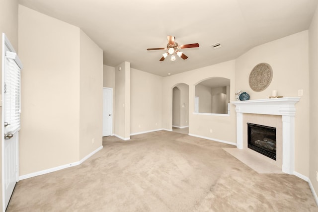 20234 Goss Hollow Ln, Katy, TX 77449 - unfurnished living room featuring a ceiling fan, a tiled fireplace, carpet flooring, and arched walkways