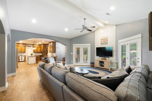 194 2 Mile Ln, Smithville, TX 78957 - living room featuring arched walkways, light wood-type flooring, beamed ceiling, a ceiling fan, and high vaulted ceiling