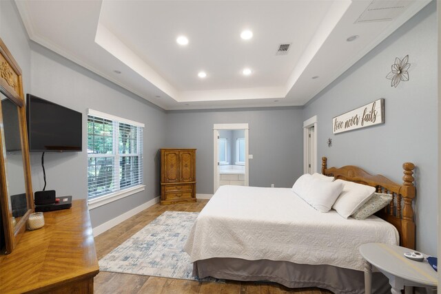 194 2 Mile Ln, Smithville, TX 78957 - bedroom with recessed lighting, a raised ceiling, light wood-type flooring, and connected bathroom