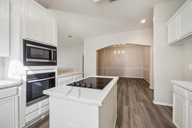 12319 Georgetown Park Ct, Houston, TX 77058 - kitchen featuring appliances with stainless steel finishes, arched walkways, dark wood-type flooring, a center island, and recessed lighting