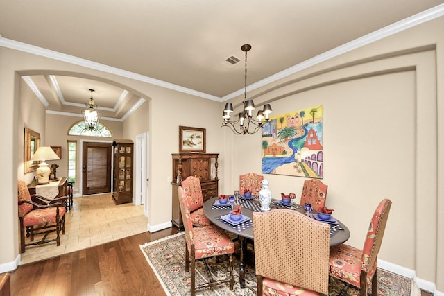 9419 Pecos Pass Ct, Cypress, TX 77433 - dining room featuring arched walkways, a chandelier, wood finished floors, crown molding, and a raised ceiling