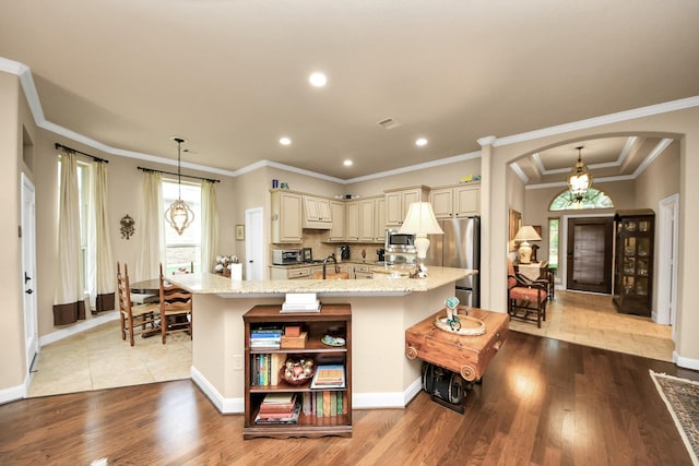 9419 Pecos Pass Ct, Cypress, TX 77433 - kitchen with cream cabinets, stainless steel appliances, arched walkways, open shelves, and wood finished floors