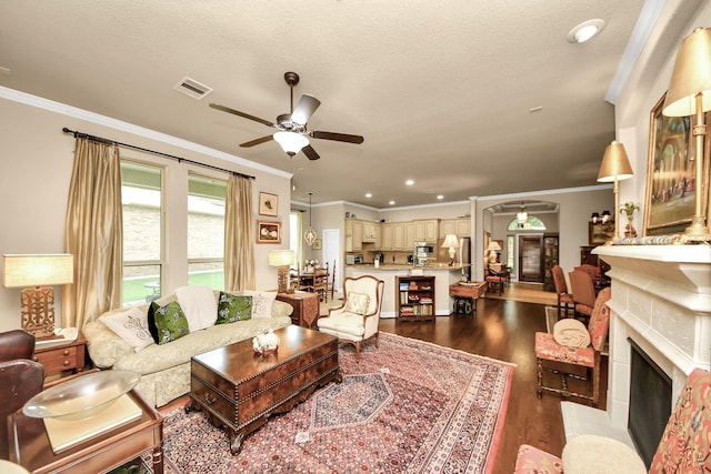9419 Pecos Pass Ct, Cypress, TX 77433 - living room featuring ceiling fan, ornamental molding, dark wood-type flooring, a fireplace with flush hearth, and recessed lighting