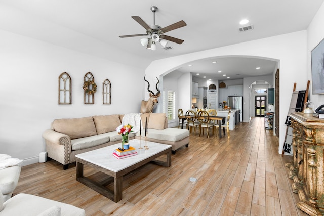 29126 Sage Meadow Trl, Fulshear, TX 77441 - living room with arched walkways, ceiling fan, light wood-style flooring, and recessed lighting