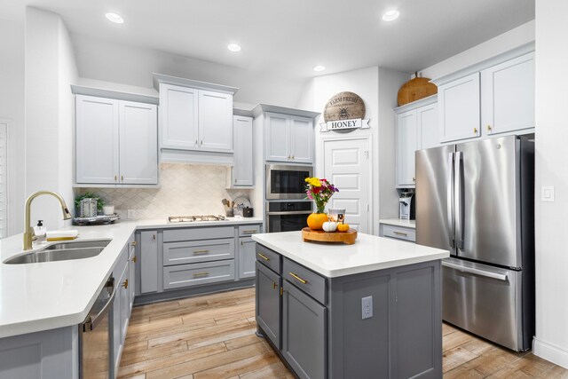 29126 Sage Meadow Trl, Fulshear, TX 77441 - kitchen with appliances with stainless steel finishes, gray cabinetry, light wood-style floors, light countertops, and tasteful backsplash