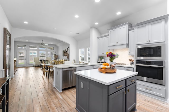 29126 Sage Meadow Trl, Fulshear, TX 77441 - kitchen featuring appliances with stainless steel finishes, a center island, a ceiling fan, gray cabinets, and light countertops