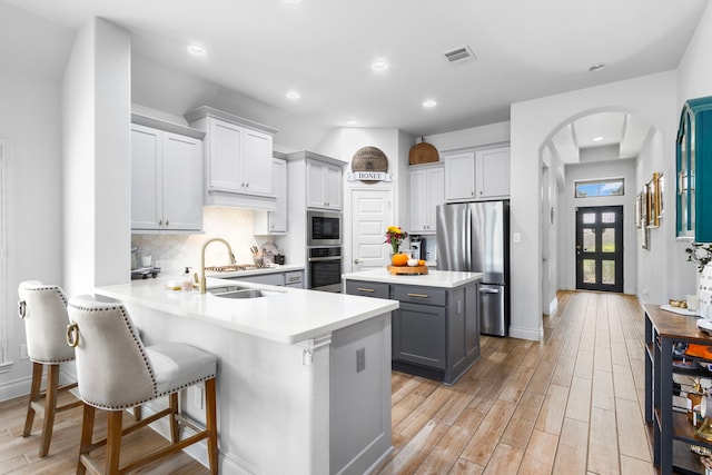 29126 Sage Meadow Trl, Fulshear, TX 77441 - kitchen with appliances with stainless steel finishes, gray cabinetry, light countertops, light wood-style floors, and recessed lighting