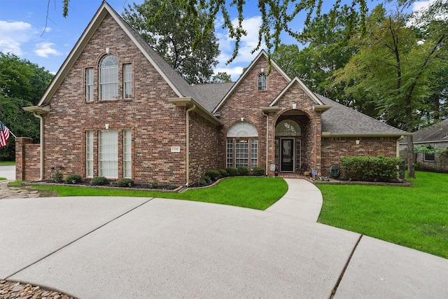 3330 Lake Island Dr, Montgomery, TX 77356 - traditional-style home with a front lawn, roof with shingles, and brick siding