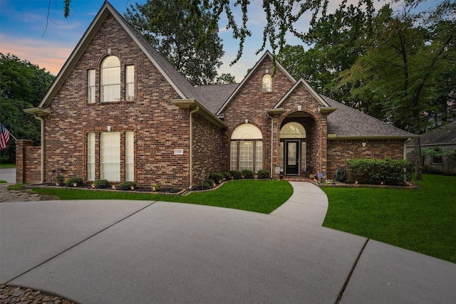3330 Lake Island Dr, Montgomery, TX 77356 - traditional-style house featuring a front yard, a shingled roof, and brick siding