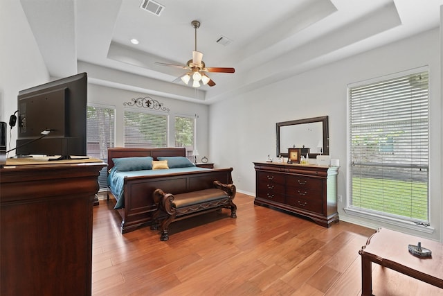 3330 Lake Island Dr, Montgomery, TX 77356 - bedroom with a raised ceiling, light wood-style flooring, and a ceiling fan