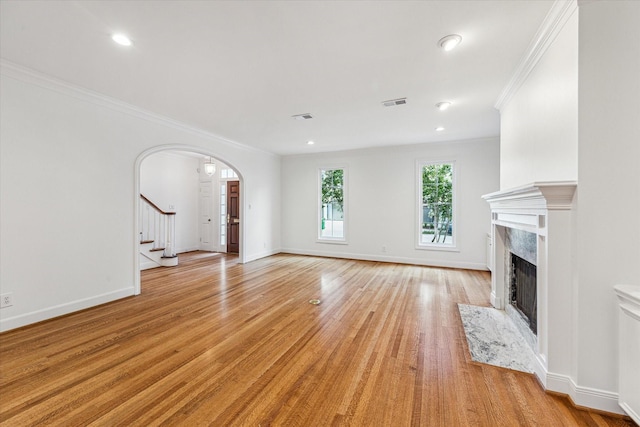 1976 Vermont St, Houston, TX 77019 - unfurnished living room featuring arched walkways, stairs, a fireplace, light wood finished floors, and crown molding